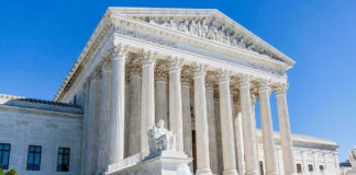 Supreme Court building with columns, fountain, and statue