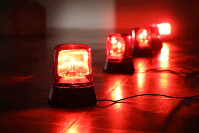 shutterstock_1042134532.jpg Red emergency lights on dark floor, illuminating the area.