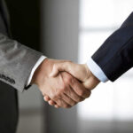 Trump Announces High-Stakes Meeting Two people in business suits shaking hands.