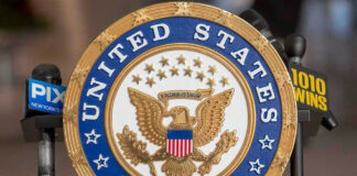 United States Senate seal with microphones in front.