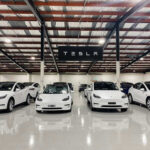 Investigation Threatens Tesla Empire White Tesla cars displayed in showroom with Tesla sign