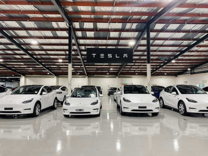 shutterstock_2190200775.jpg White Tesla cars displayed in showroom with Tesla sign