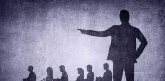 Shadows of laid-off workers walking, large figure pointing.