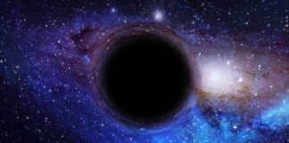 A black hole surrounded by a colorful galaxy filled with stars