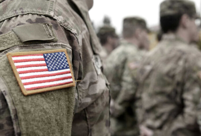Soldiers in camouflage uniforms with American flag patches.
