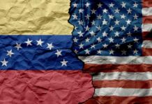 Crumpled flags of Venezuela and the United States split in the center