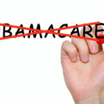 Hand crossing out the word Obamacare in red
