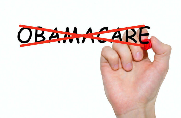 shutterstock558637486jpg Hand crossing out the word Obamacare in red