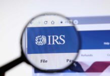 Magnifying glass focusing on IRS website logo.