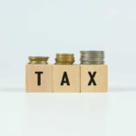 $144 BILLION Tax Bombshell — Nobody Expected This Blocks spelling 'TAX' with coins stacked beside them