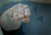 Fist with Woke written on fingers.
