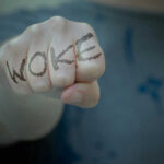 Fist with Woke written on fingers.