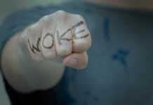 Trump SLASHES Woke Park Days Fist with Woke written on fingers.