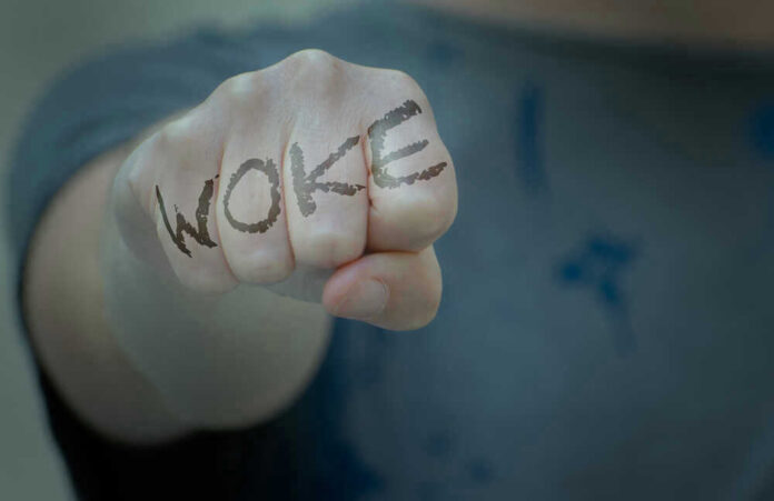 shutterstock_2002018643.jpg Fist with Woke written on fingers.