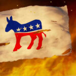 Torn Democratic flag burning amid flames and embers.