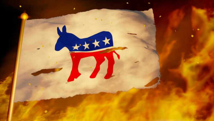 shutterstock_2206000525.jpg Torn Democratic flag burning amid flames and embers.
