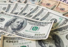 Stacks of various U.S. dollar bills.