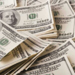 Stacks of one hundred dollar bills scattered.