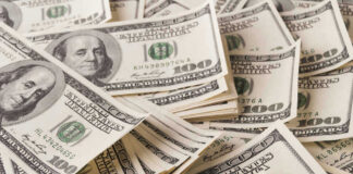 Stacks of one hundred dollar bills scattered.
