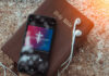 Smartphone displaying worship music on top of a Holy Bible