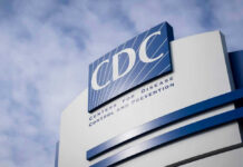 CDC building sign against a cloudy sky.