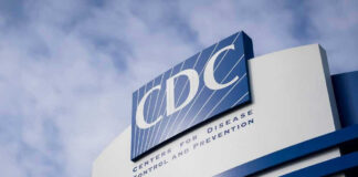CDC building sign against a cloudy sky.