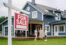Home Sales FREEFALL — Is the Market Crashing? For sale sign in front of a house with potential buyers discussing