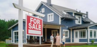 For sale sign in front of a house with potential buyers discussing