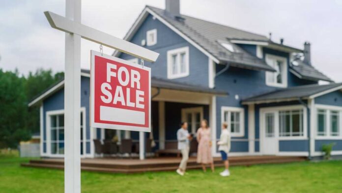 shutterstock_2222205237.jpg For sale sign in front of a house with potential buyers discussing