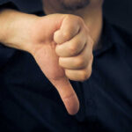 These Gift Cards WORTHLESS — Customers Devastated Hand showing thumbs down gesture, dark background.