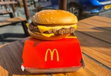 McDonald’s Announces Huge Surge A cheeseburger from McDonald's placed on a red box on a wooden table