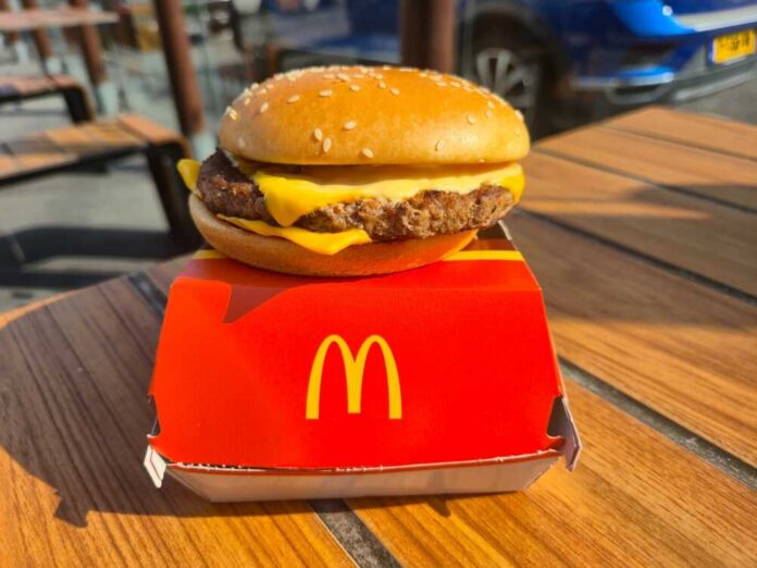 shutterstock_2646644985.jpg A cheeseburger from McDonald's placed on a red box on a wooden table