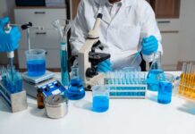 Scientists Unearth Brain Clue for Sharp Seniors Scientist in a lab working with blue liquids and a microscope