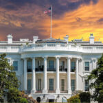 White House SPINS Weak Jobs as Immigration Win The White House with vibrant sunset sky.