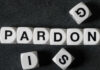 White letter blocks spelling 'PARDON' on a black surface