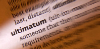 Close-up of a dictionary page showing the definition of 'ultimatum'