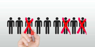 Hand crossing out stick figures with a red marker.