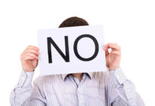 Person holding a sign that says 'NO' in large letters