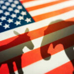 Donkey and elephant silhouettes on American flag background.