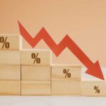 Recession Odds SPIKE Wooden blocks with percentage symbols and a downward arrow indicating decline