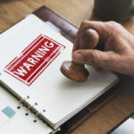 Terror Warning SUPPRESSED? A hand applying a warning stamp on a document