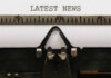 DEADLIEST CATCH Star DIES on Camera Close-up of a typewriter with a sheet of paper displaying the words 'LATEST NEWS'
