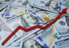 A pile of hundred dollar bills with a red upward trend line overlay