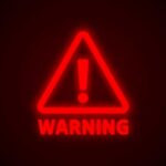 Red neon warning sign with an exclamation mark