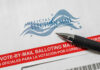 Judges Claim Racial Map Scandal Vote-by-mail envelope with pen on top.