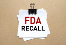 Recall Explodes Over Three Missing Words A notice labeled 'FDA RECALL' clipped to white papers on a brown background