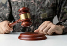 Military person holding gavel near desk