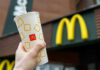 Shocking Hot Oil Attack Inside McDonald’s Hand holding McDonalds cup in front of restaurant sign.