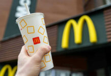 Shocking Hot Oil Attack Inside McDonald’s Hand holding McDonalds cup in front of restaurant sign.