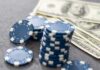 Stack of blue poker chips next to cash bills
